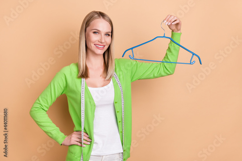 Photo portrait blonde woman keeping garment measuring line clothes designer isolated pastel beige color background