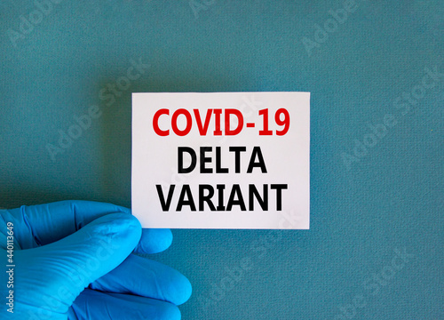 New covid-19 delta variant strain symbol. Doctor hand in blue glove with white card. Concept words 'covid-19 delta variant'. Medical and COVID-19 delta variant strain concept. Copy space.