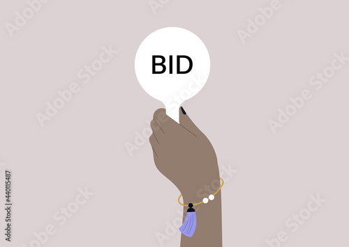 Hand holding an auction paddle, a bidder