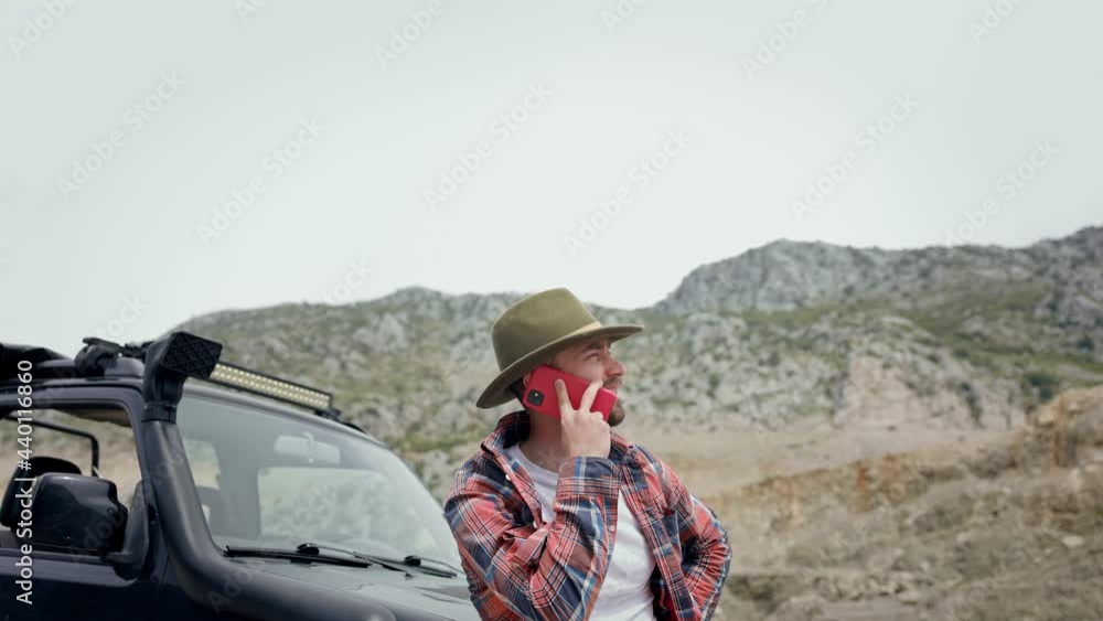 Guy In Hat Near Car. Around Rock. He Is Talking On The Phone. Guy In Hat Near Car. Around Rock. He Is Talking On The Phone.