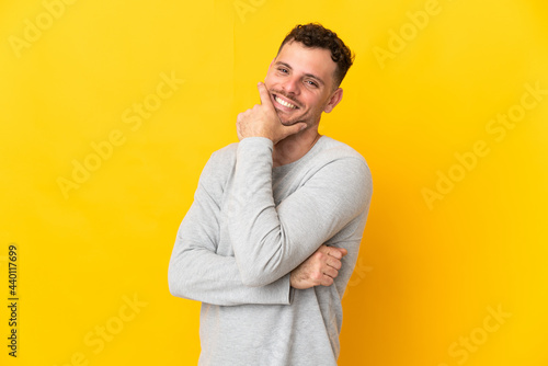 Young caucasian handsome man isolated on yellow background happy and smiling