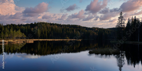 Sunrise over the lake. The sky is dramatic and on fire. Shot in Nordmarka, Oslo, Norway. 