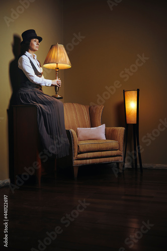 Woman holding lamp in darkroom