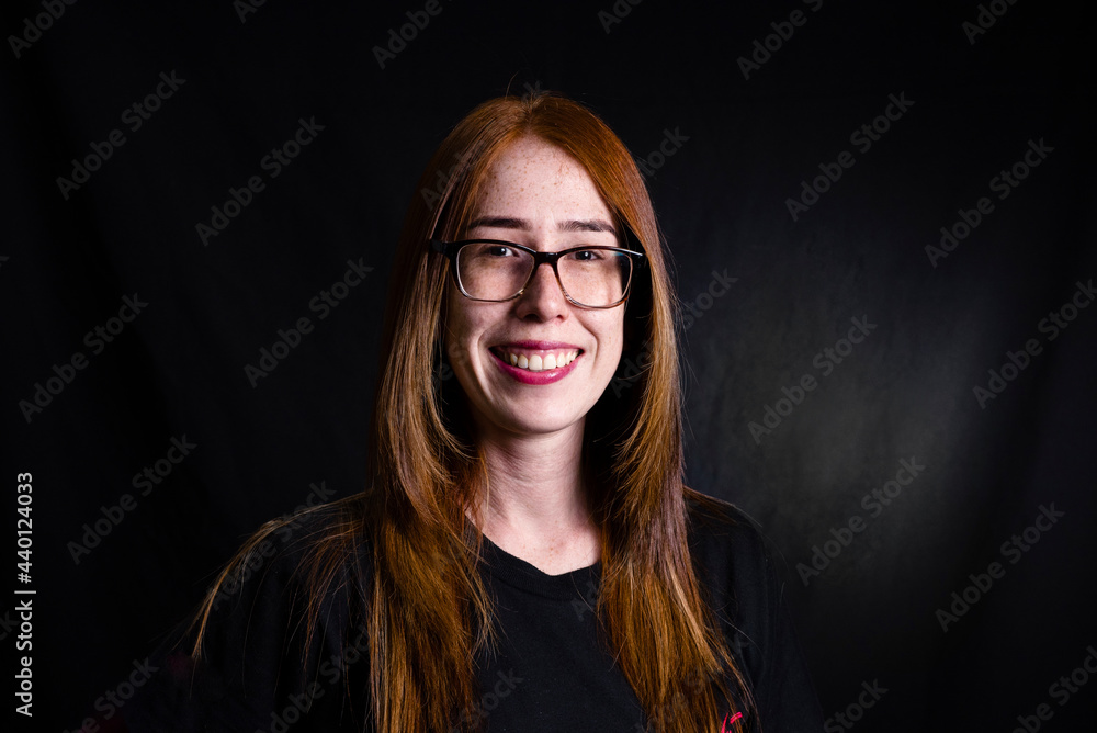 Smiling woman wearing eyeglasses against black background Smiling woman wearing eyeglasses against black background