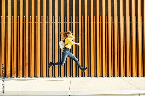 Woman checking time while running over footpath