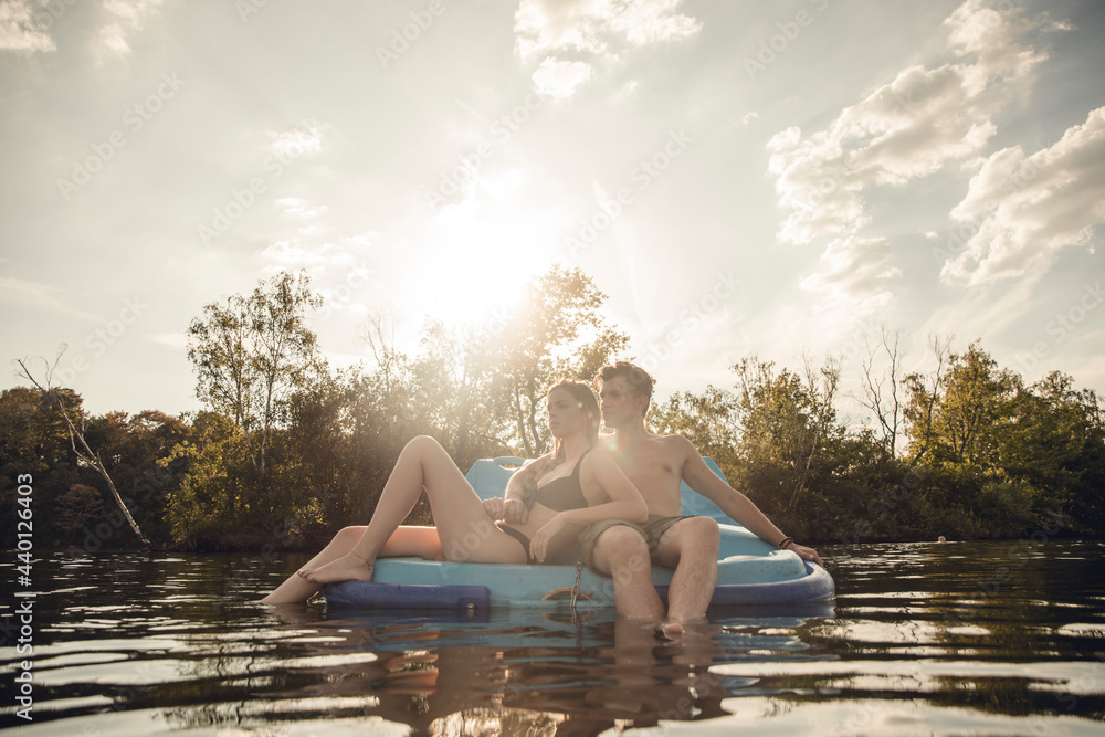 Young couple sitting on a boat on the lake, relaxing Young couple sitting on a boat on the lake, relaxing