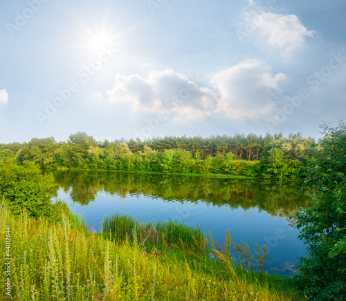 small quiet lake with forest on coast at the sunny day