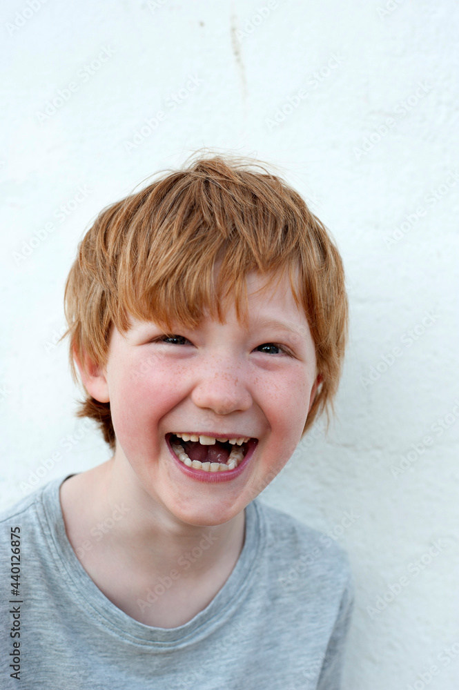 © Gianna Schade/Westend61 - Laughing redhead boy in front of white wall