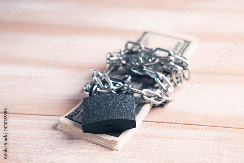 money wrapped in a chain and closed with a padlock
