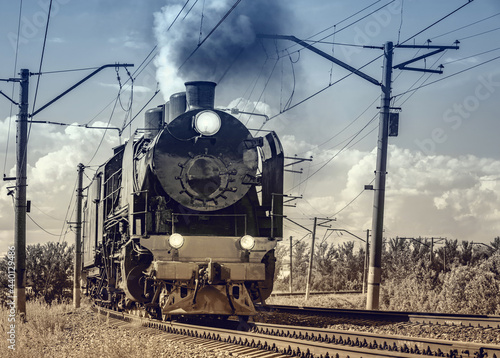 Retro train moves at day time. Vintage style image.