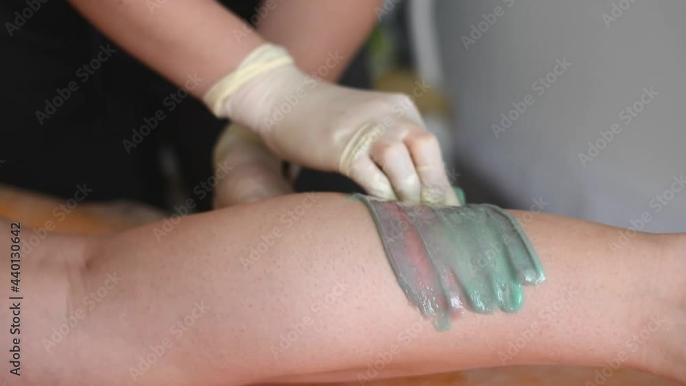 Applying the master sugar paste to depilation on the leg Applying the master sugar paste to depilation on the leg