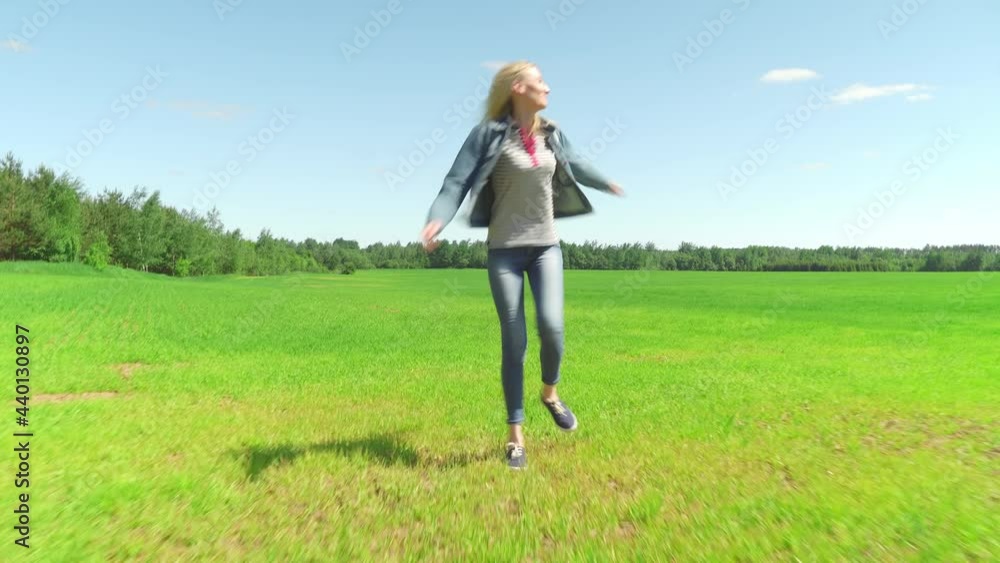 Woman dancing feel happy in the landscape grass field meadow nature summer in the sun hair young spring model pretty relax happiness. She's wearing a denim suit, and jeans. Woman dancing feel happy in the landscape grass field meadow nature summer in the sun hair young spring model pretty relax happiness. She's wearing a denim suit, and jeans.
