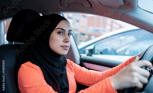 Thoughtful Arab woman looking away while driving car photo