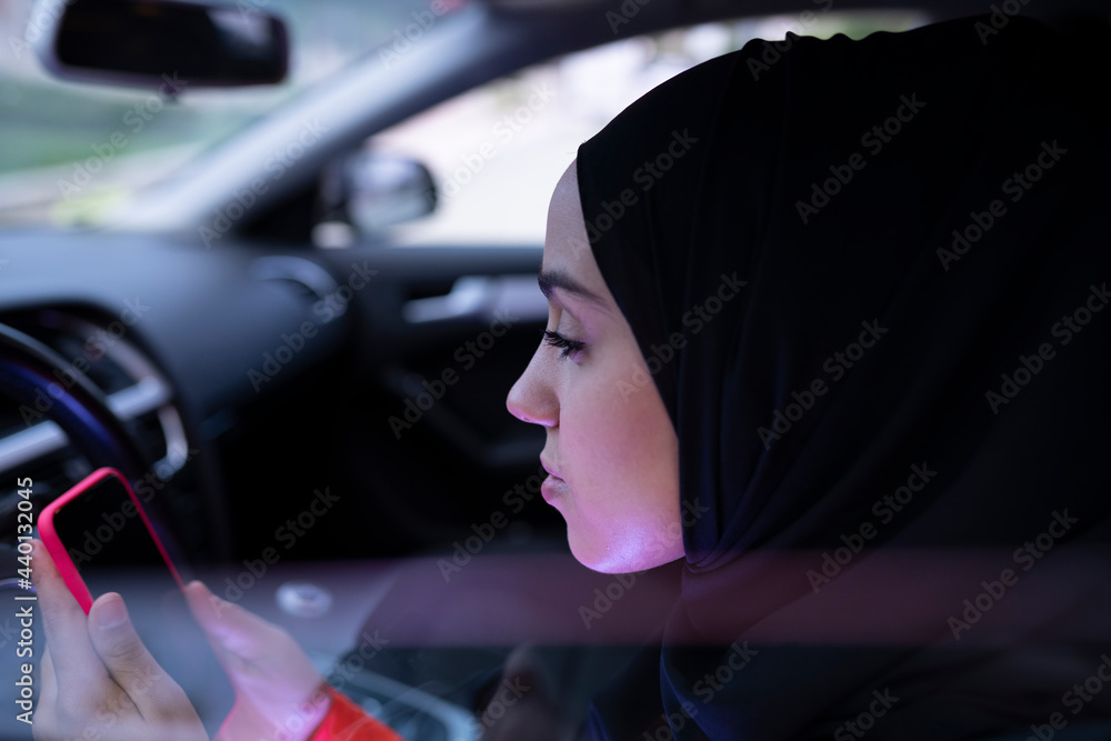 Woman using smart phone while sitting in car Woman using smart phone while sitting in car