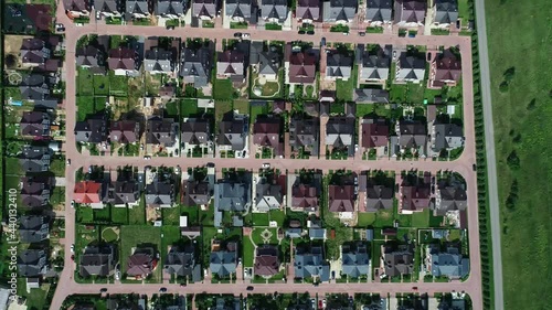 Aerial drone view shot of real estate. Summer sunny day. Suburban neighborhood residential houses. Establishing shot of suburb, streets. Residential single family houses.