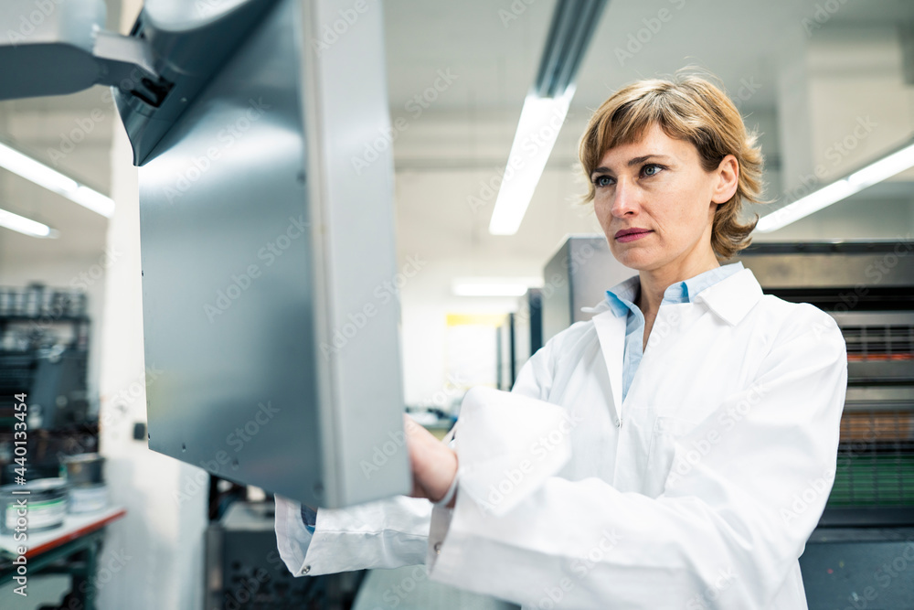 Female scientist operating printing machine in laboratory Female scientist operating printing machine in laboratory