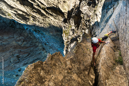 Determined male climber climbing rock mountain