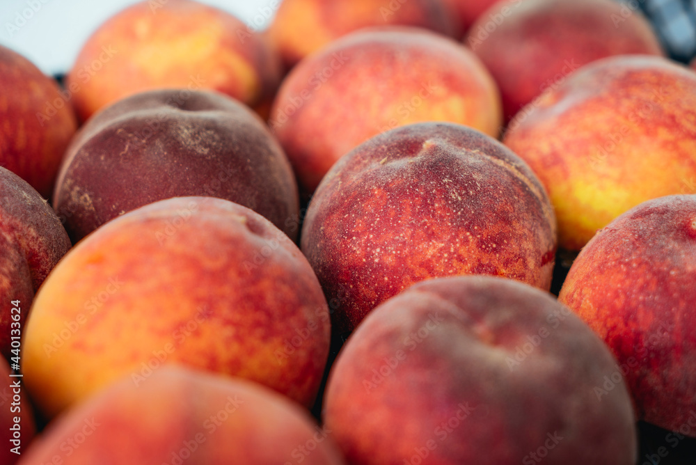 Peaches in a black box. Many peaches on the market. Box full of fresh picked peaches. Close-up of colorful fruit. Organic food for health. Vitamins. Depth of field Peaches in a black box. Many peaches on the market. Box full of fresh picked peaches. Close-up of colorful fruit. Organic food for health. Vitamins. Depth of field