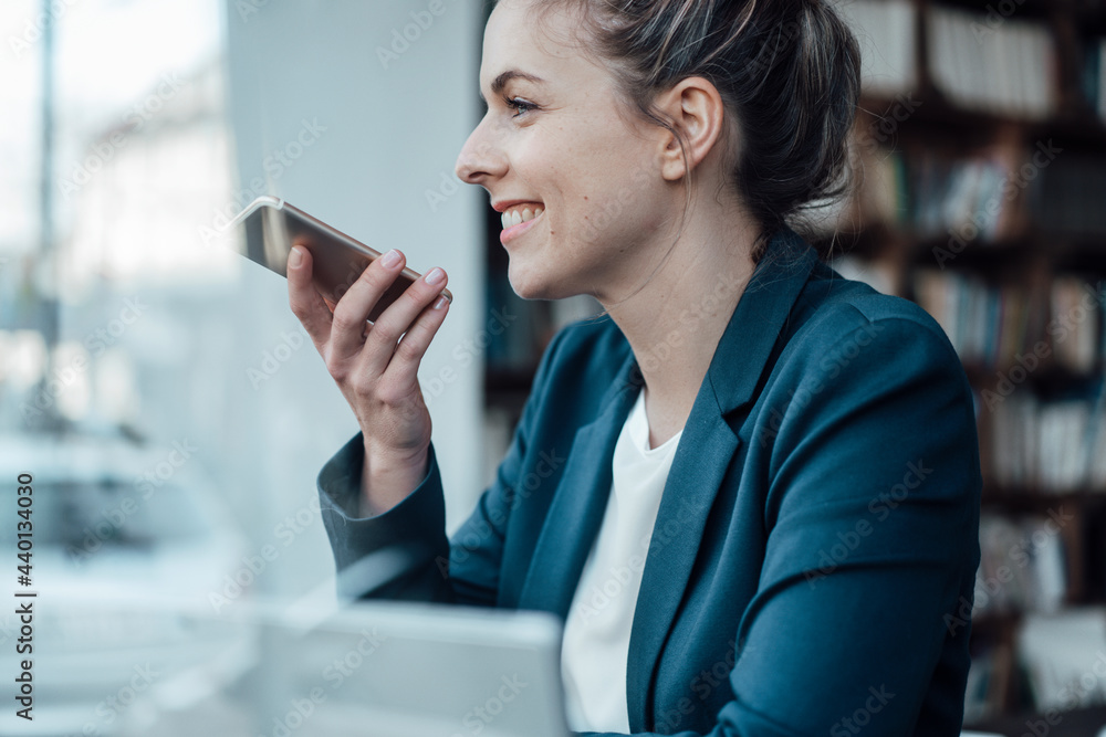 Smiling businesswoman talking on mobile phone at cafe Smiling businesswoman talking on mobile phone at cafe
