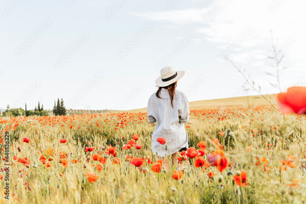 © Mar/Westend61 - Woman wearing hat standing in poppy field