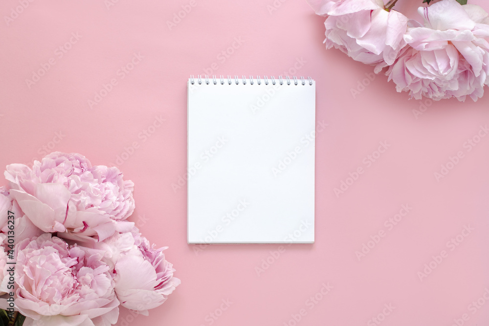 Greeting card design for birthday, wedding, mother's day, valentine's day. Pink peony flowers on a pink background. White blank text sheet. Trendy flat lay. Romantic layout, top view
