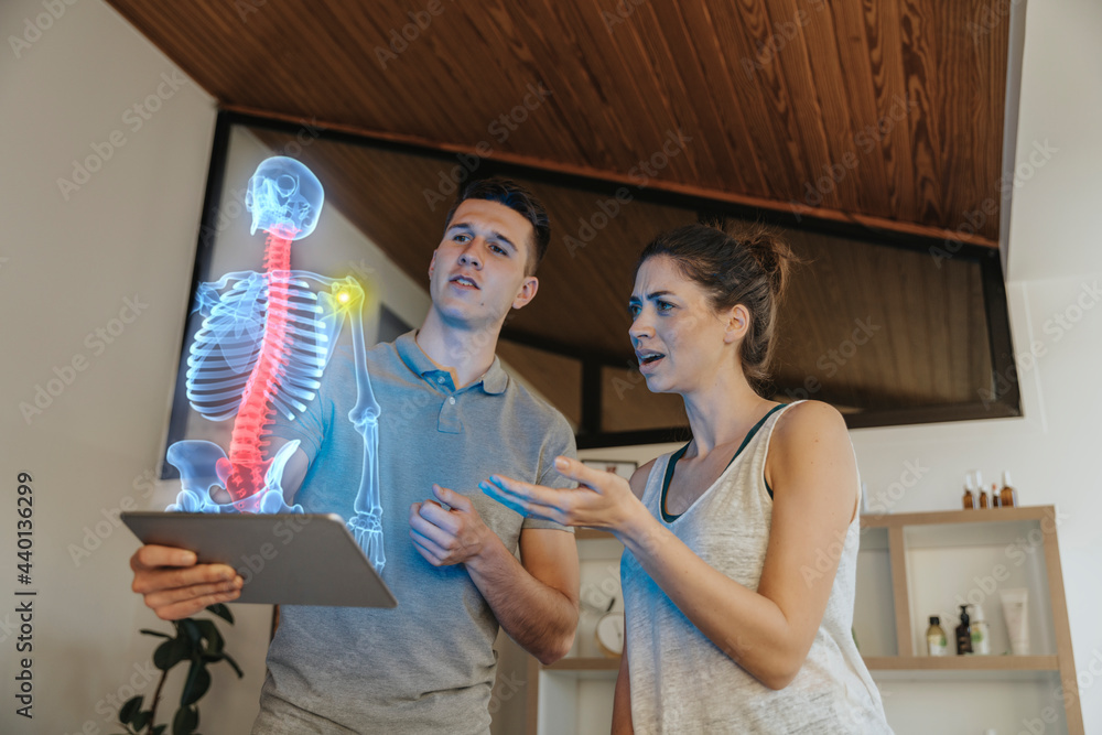 © Infinite Lux/Westend61 - Physiotherapist showing cause of pain in the shoulder joint to female patient