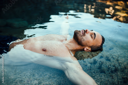 Man with eyes closed lying on water during vacations photo