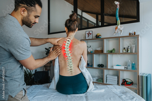 Physiotherapist treating female patient's bent spine photo