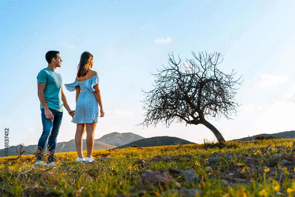 Couple looking at view while standing together on grass Couple looking at view while standing together on grass