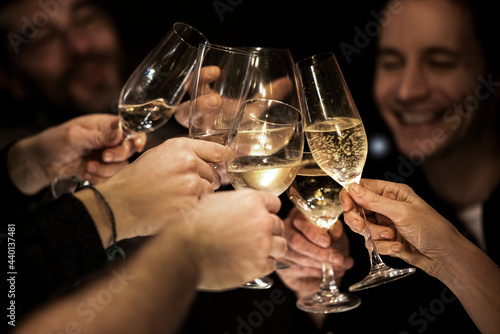 Happy male and female friends toasting glasses during celebration at home photo