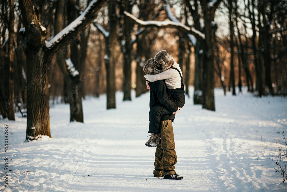 Boyfriend carrying girlfriend while standing on snow in forest Boyfriend carrying girlfriend while standing on snow in forest