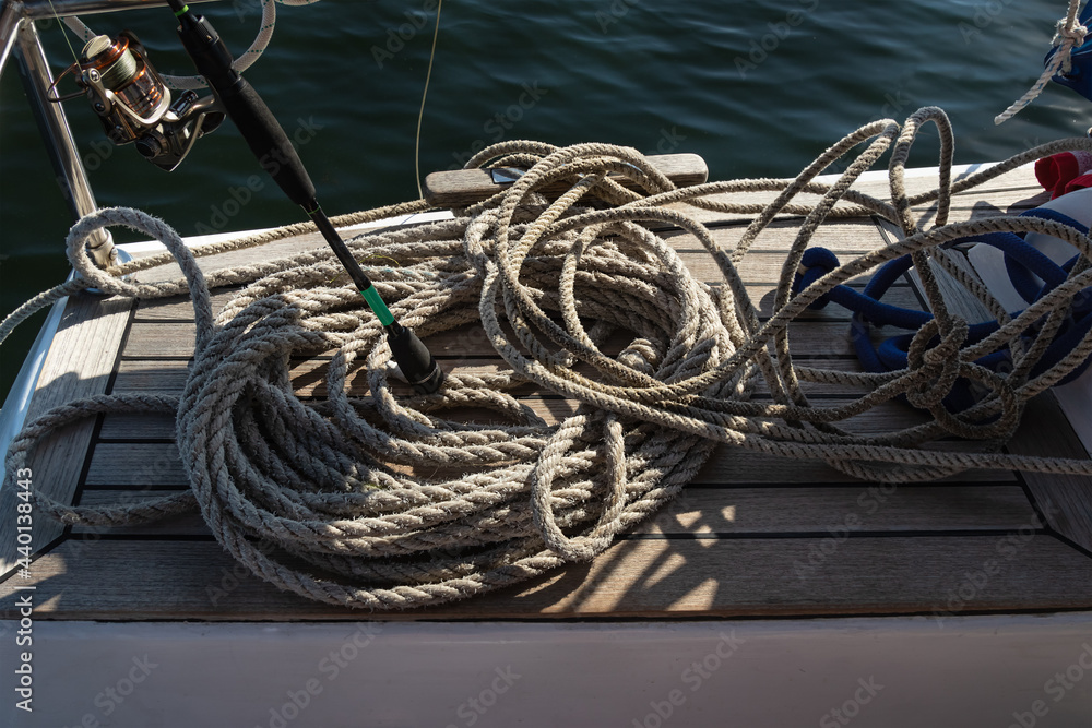 cables and twine on deck of the boat. Sailboat on water surface in calm