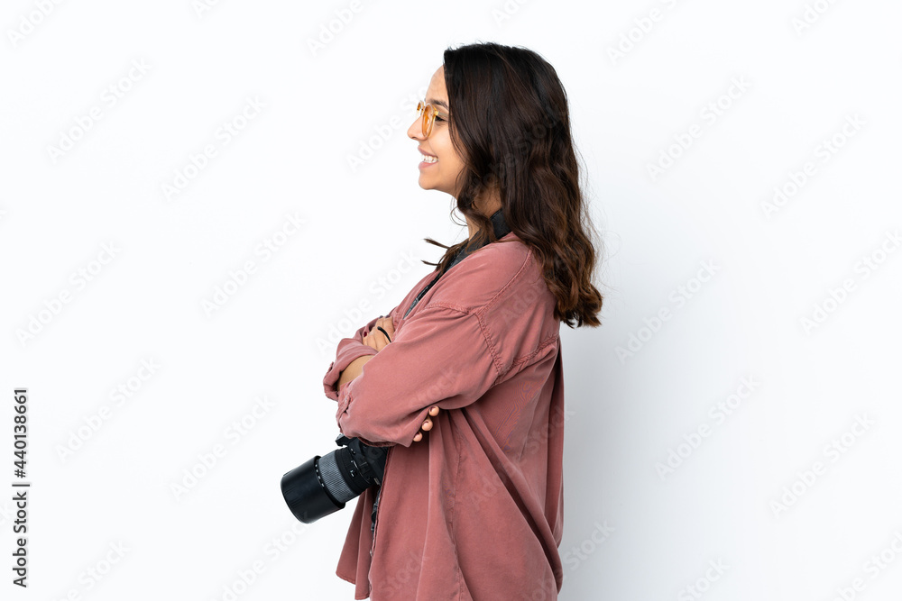 Young photographer woman over isolated white background in lateral position Young photographer woman over isolated white background in lateral position
