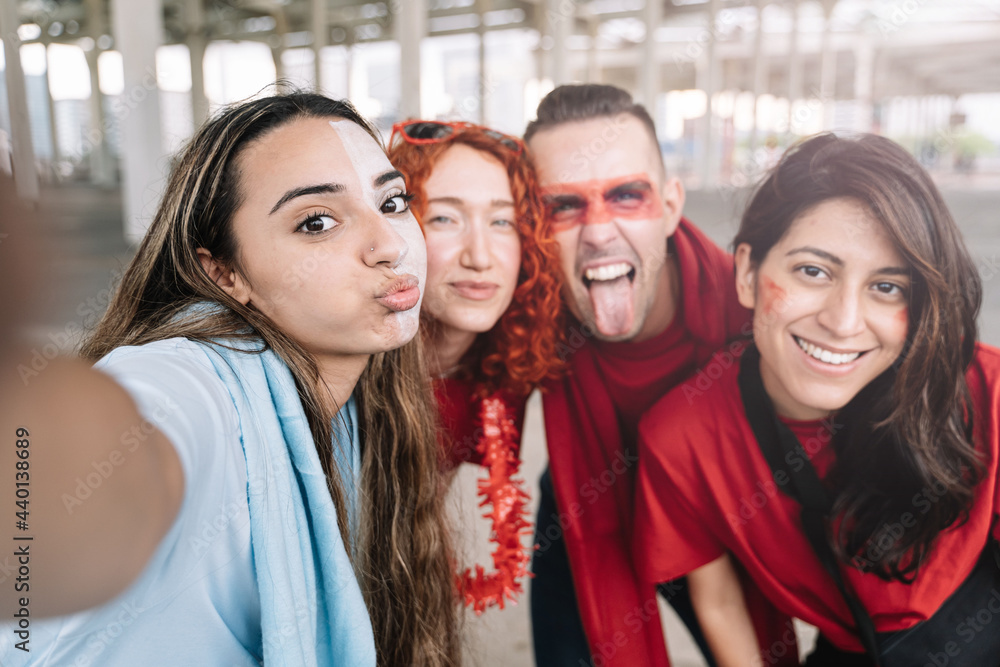 Group of friends taking selfie in the football stadium before the sport event - Young soccer fans sharing joy on social media Group of friends taking selfie in the football stadium before the sport event - Young soccer fans sharing joy on social media