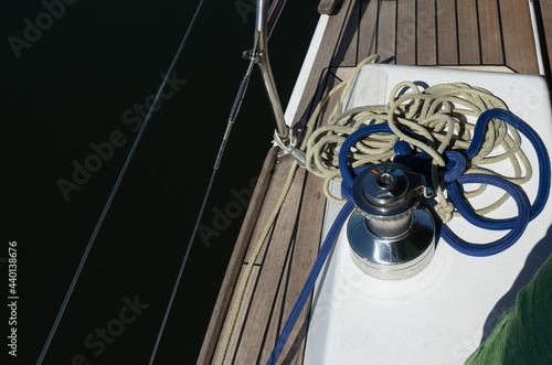cables and twine on deck of the boat. Sailboat on water surface in calm