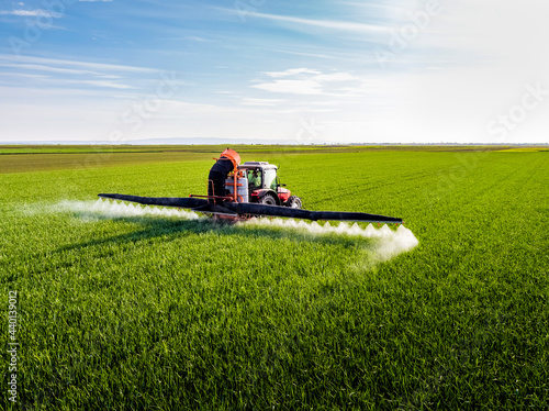 Farmer fertilizing crop through crop sprayer in field