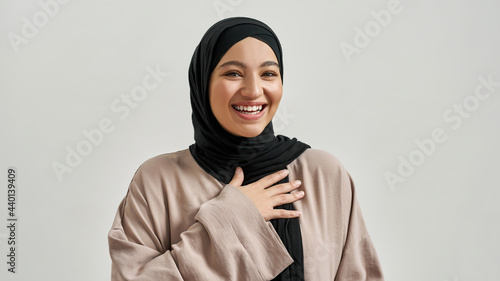 Portrait of laughing young arabic woman in hijab photo