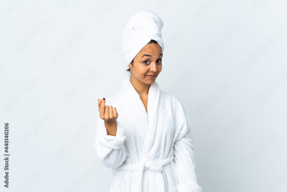 Young woman in bathrobe over isolated white background making money gesture Young woman in bathrobe over isolated white background making money gesture