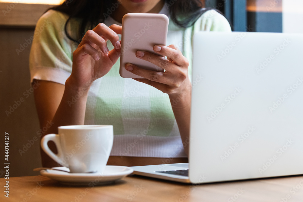 Woman with laptop and coffee cup using smart phone at cafe Woman with laptop and coffee cup using smart phone at cafe