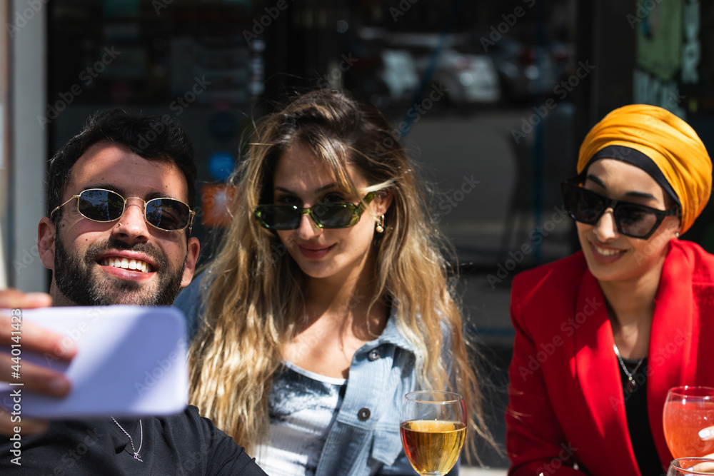 Young man taking selfie with female friends at bar Young man taking selfie with female friends at bar