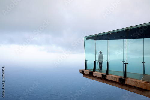 Man standing on skywalk in front of sky photo