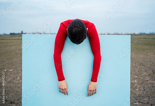 Woman leaning on blue painting photo