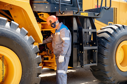 Professional mechanic checks hydraulic hose system equipment on excavator to raise bucket