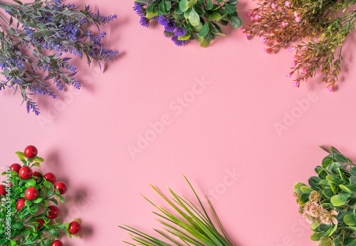 Flat layout of dried flower branches on a pink background, top view.