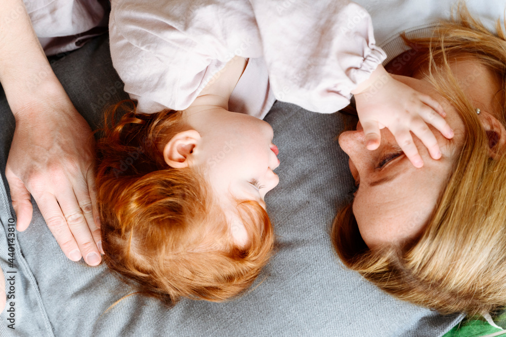 Daughter stroking mother while lying on bed at home Daughter stroking mother while lying on bed at home