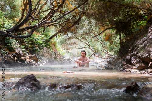 Shirtless man relaxing in thermal river, Rotorura, New zealand photo