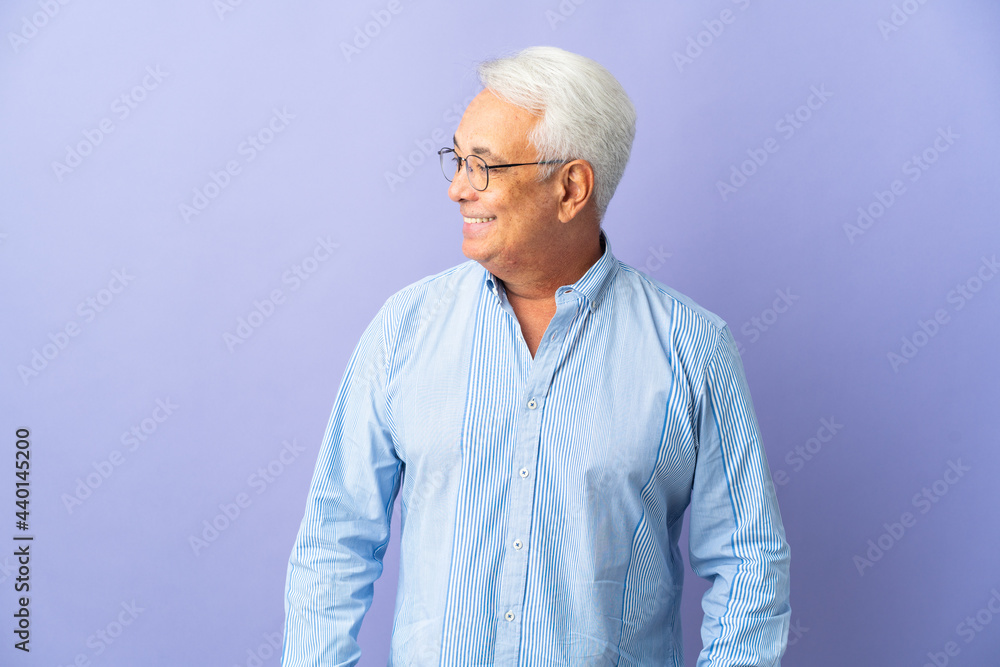 Middle age Brazilian man isolated on purple background looking side Middle age Brazilian man isolated on purple background looking side