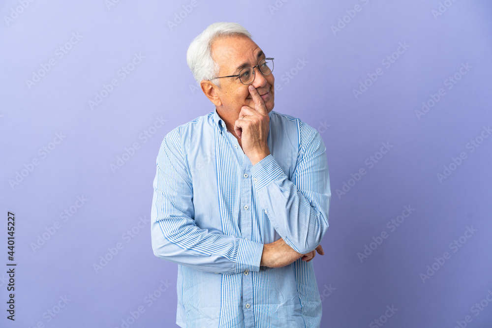 Middle age Brazilian man isolated on purple background thinking an idea while looking up Middle age Brazilian man isolated on purple background thinking an idea while looking up