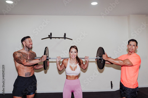 Male athletes helping friend in weightlifting photo