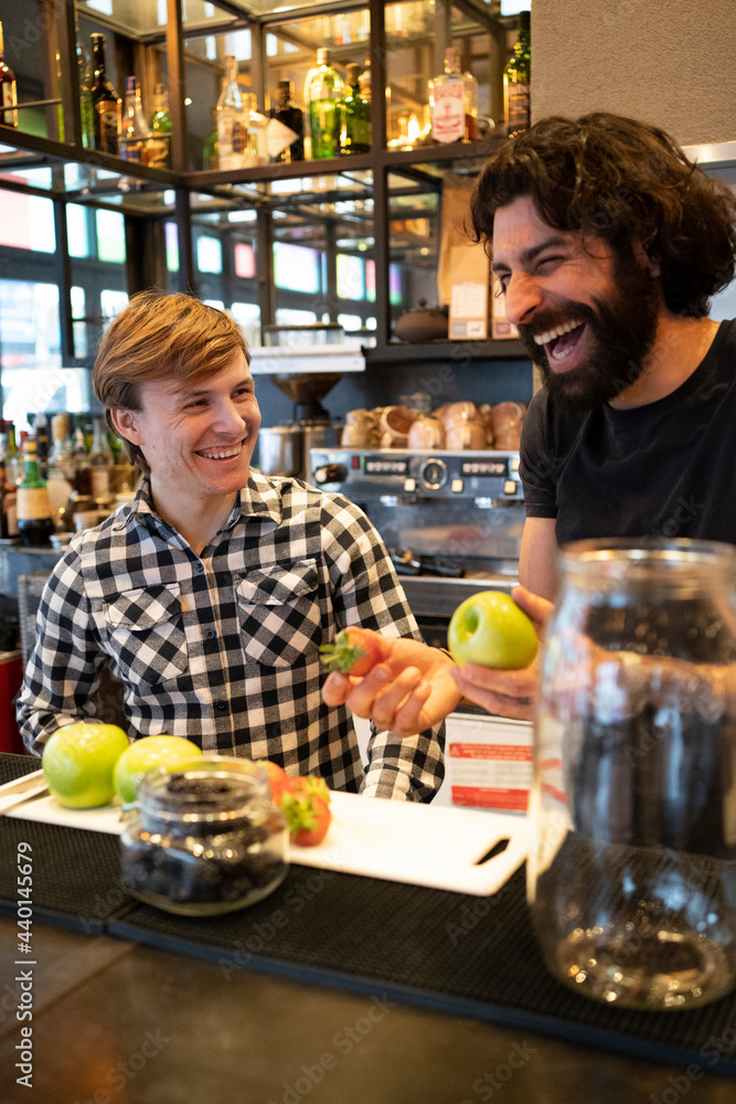 © Francesco Buttitta/Westend61 - Male bartender laughing while holding fresh fruit by trainee at bar counter © Francesco Buttitta/Westend61 - Male bartender laughing while holding fresh fruit by trainee at bar counter